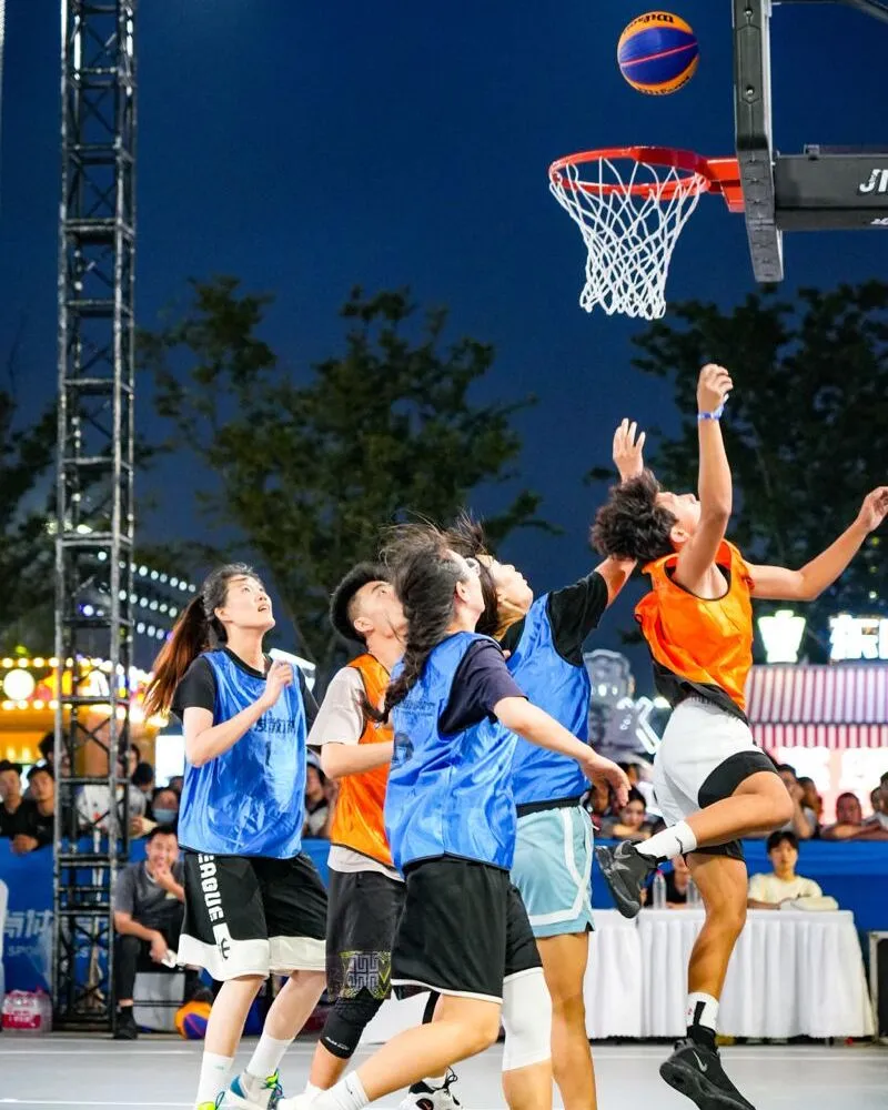 girls wearing blue and orange custom basketball uniforms playing in basketball court