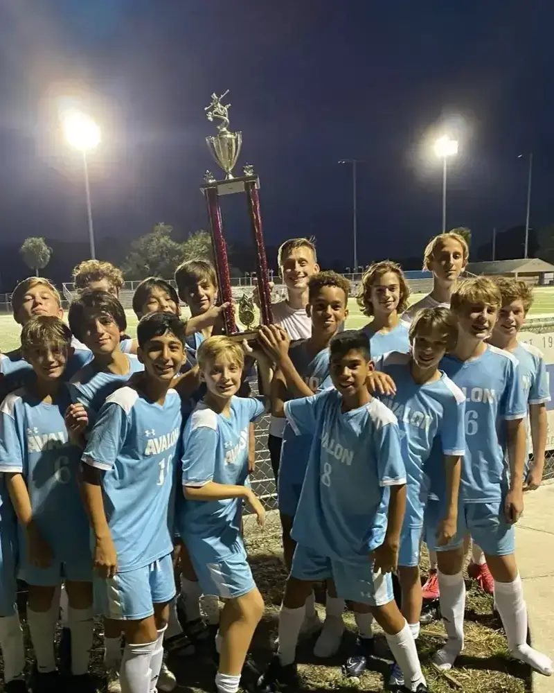 local school team wearing sky blue custom soccer uniforms standing in ground